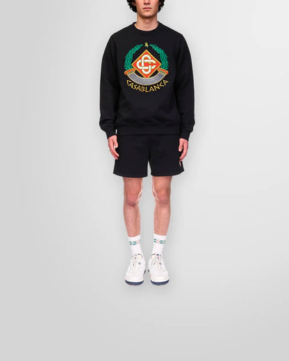 Lifestyle image of the Casa Crest Sweatshirt paired with black cotton shorts.